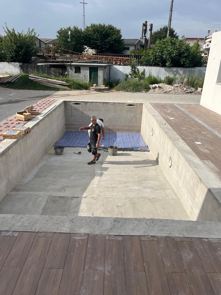Piscina em construção: a equipa começa a assentar o mosaico azul no fundo da piscina