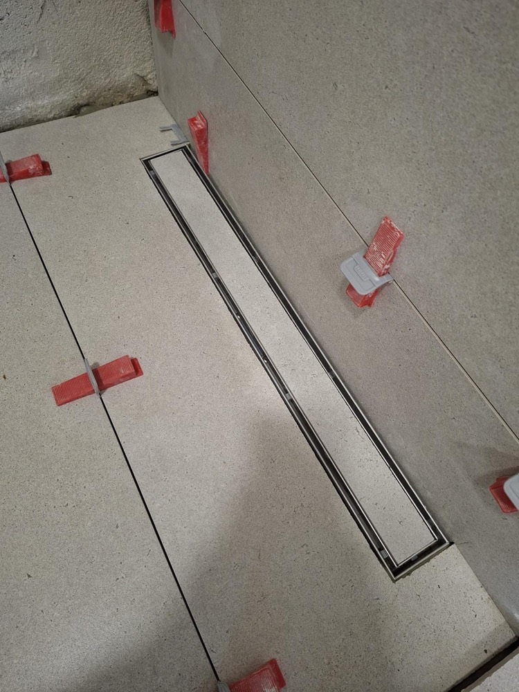 Ralo linear de duche embutido no pavimento cerâmico, com a tampa revestida no mesmo material